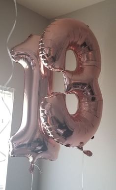 a balloon shaped like the number thirty five is hanging from a ceiling in a room