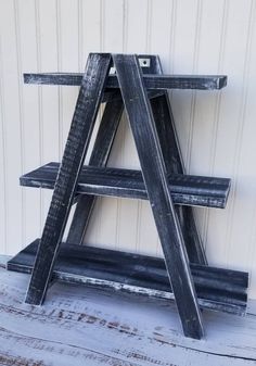 three tiered wooden shelf sitting on top of a floor