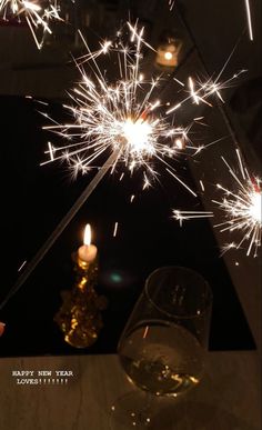 a glass of wine and some sparklers on a table