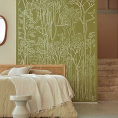 a bed sitting under a window next to a wall with plants on it and a mirror