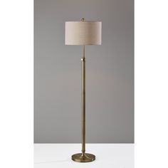 a floor lamp with a beige shade on it's base and a white drum light