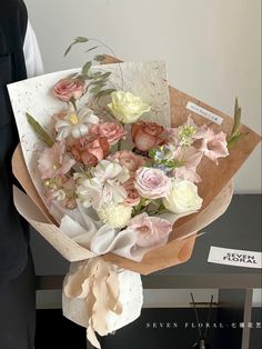 a woman holding a bouquet of flowers on top of a table