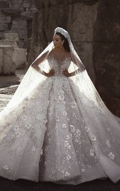 a woman in a wedding dress standing next to some rocks