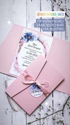 the wedding card is pink and has a ribbon on it, with an elegant floral design