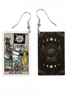 two tarot cards are hanging from earrings