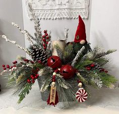 a christmas centerpiece with candy canes, pine cones and other holiday decorations on a table