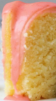 a piece of cake with pink frosting on it sitting on top of a white plate