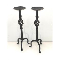 two black metal candlesticks sitting next to each other