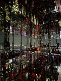 the reflection of city lights and skyscrapers is shown in this glass walled building's windows