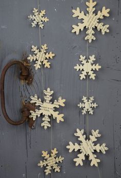 snowflakes are hanging on a gray wall