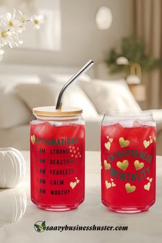 two red jars with straws and some writing on them