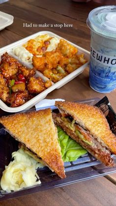 a sandwich cut in half on top of a plastic container with other food items next to it