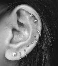 a woman's ear with multiple piercings on it