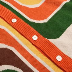 Retro Knitted V-neck Tops, Multicolor Knit V-neck Sweater Vest, Multicolor V-neck Knit Sweater Vest, Retro Green V-neck Sweater, Trendy Multicolor V-neck Sweater Vest, Orange V-neck Knit Sweater, Trendy Orange V-neck Sweater, Retro V-neck Cardigan For Fall, Retro Knit Stretch Sweater