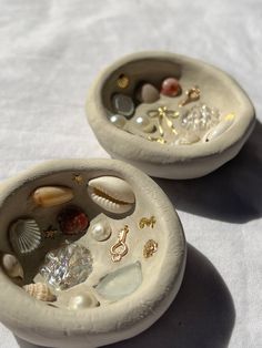 two small bowls with shells and seashells in them