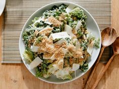 a white bowl filled with broccoli and cheese on top of a wooden table