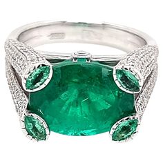 A truly special kind of a ring. Presenting an exquisite masterpiece, a truly unique and opulent ring adorned with a certified 5.50-carat oval Colombian emerald of unparalleled quality, certified by GRS. This captivating gem, possessing a rich and vivid hue, commands attention with its natural beauty and rarity. Elevated to perfection, the emerald is accompanied by four meticulously selected marquise emeralds, artfully arranged to accentuate its splendor. A harmonious balance is achieved by the i Luxury Diamond Ring With Emerald Accent Stones, Formal Round Emerald Ring With Pave Setting, Luxury Emerald Ring With Diamond, Formal Platinum Emerald Ring With Pave Setting, Luxury Gia Certified Emerald Diamond Ring, Oval Emerald Ring With Pave Setting In Platinum, Luxury Emerald Ring With Accent Stones, Luxury Emerald Ring With Accent Stones For Formal Occasions, Luxury Green Diamond Ring