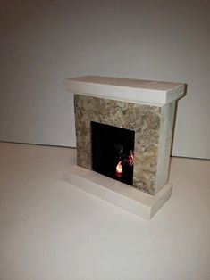 a white fireplace with a lit candle in it