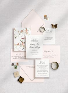 the wedding stationery is laid out on top of each other, including an envelope and two