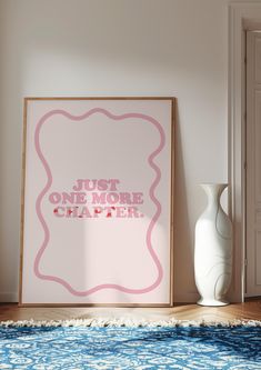 a white vase sitting on top of a blue rug next to a pink and white poster