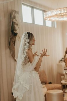 a woman in a wedding dress standing next to a mirror