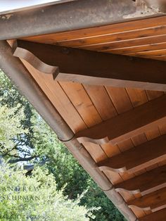 the roof of a wooden building with trees in the background