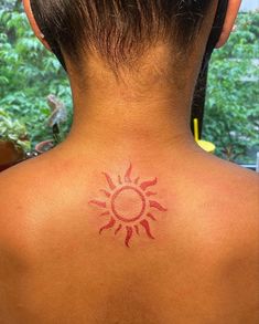 a woman with a sun tattoo on her back