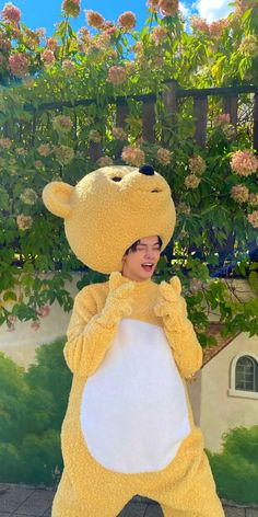 a woman dressed in a bear costume standing on one leg and smiling at the camera