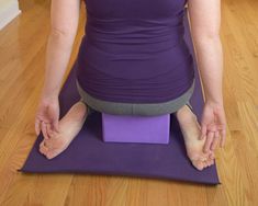 a woman is sitting on a yoga mat