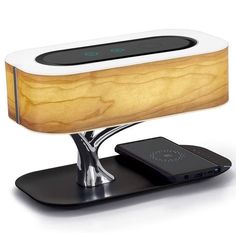 an electronic device is sitting on top of a wooden stand with a cell phone in it