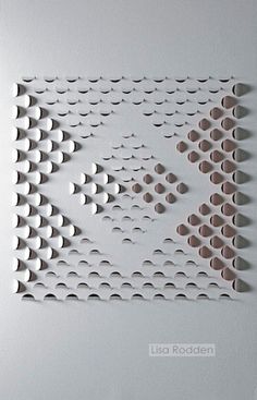 a white wall with holes and circles on the bottom, above it is an arrow