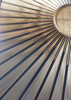 the inside of a circular wooden structure with many lines on it's sides and a skylight in the background