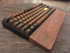 a computer keyboard sitting on top of a wooden table