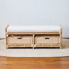 two wicker storage baskets sit on top of a rug in front of a white brick wall