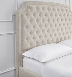 an upholstered headboard with white pillows