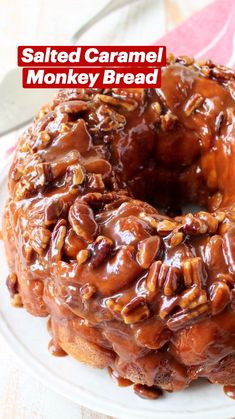 a bundt cake covered in caramel and pecans on a plate with a fork