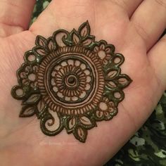 someone is holding out their hand with hendi tattoos on it's palm, which has an intricate design in the middle