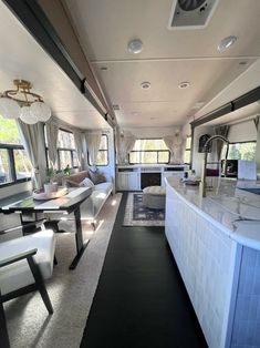 the interior of an rv with white furniture and black flooring is shown in this image