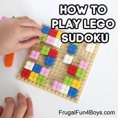 someone is playing with lego sudoku on the white table and has their hands touching it