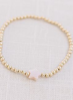 Handcrafted stretch bracelet made with a light pink mother of pearl bead and 14k gold filled 3mm beads made by artists in the USA length: 6.5 inches Dainty Adjustable Pearl Stretch Bracelet, Dainty Gold Stretch Bracelet With Gold Beads, Dainty 14k Gold-filled Stretch Bracelet With Gold Beads, Dainty Gold Bead Stretch Bracelet, Adjustable Hand-strung 14k Gold Filled Stretch Bracelet, Adjustable Pink Beaded Bracelets In 14k Gold, Dainty 14k Gold-filled Stretch Bracelet, Dainty Pink 14k Gold-filled Bracelets, Dainty Hand-strung Stretch Bracelet