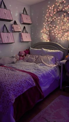 a bedroom decorated in pink and purple with lots of lights on the wall above the bed