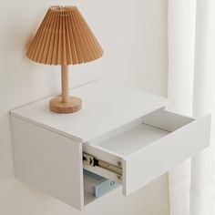 a lamp on top of a white desk next to a book shelf with files in it