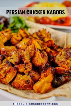 chicken kabobs on pita bread with lettuce and tomatoes in the background