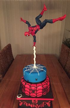 a spiderman cake on top of a wooden table