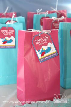 some pink and blue bags with thank you for it's birthday tags on them