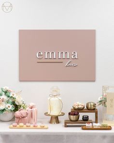 a table topped with vases filled with flowers next to a sign that says emma