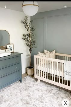 a baby's room with a crib, dresser and mirror on the wall