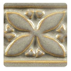 a close up of a decorative tile with flowers on it's center and leaves in the middle