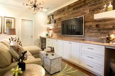 a living room filled with furniture and a flat screen tv on top of a wall