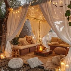 an outdoor living area with white drapes and lights